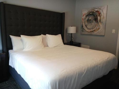Wasaga Riverdocks Hotel Suites في واساغا بيتش: سرير أبيض كبير في غرفة الفندق
