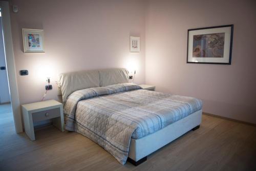 a bedroom with a bed with two tables and two lamps at Cascina Goretta Agriturismo in La Morra