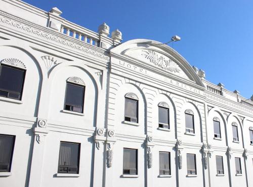 a white building with a clock on top of it at Aristos Puebla in Puebla