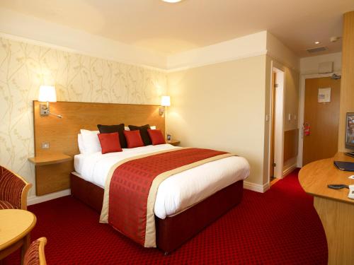 a hotel room with a large bed and a table at Best Western Plus Milford Hotel in South Milford