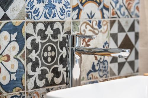 baño con grifo cromado junto a un aseo en Holiday House D' Anna 68 en Agerola
