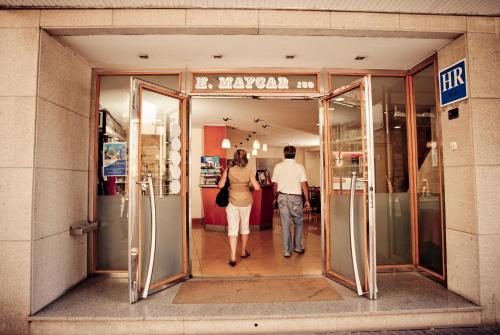 
a woman standing in front of a door in a store at Hotel Maycar in A Coruña
