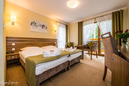 Pokój hotelowy z łóżkiem i biurkiem w obiekcie Hotel Na Skarpie w Szklarskiej Porębie