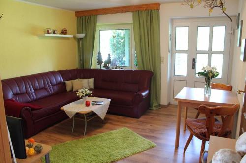 een woonkamer met een bank en een tafel bij Ferienwohnung Waitzdorf in Hohnstein