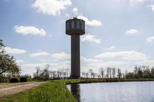 a control tower next to a body of water at Watertorenhotel Nes in Nes