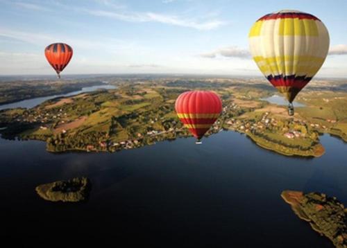 three hot air balloons flying over the water at Apartament Kaszubski in Ostrzyce