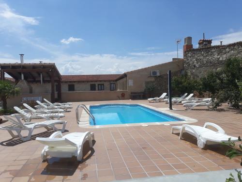 a swimming pool with lounge chairs and a swimming pool at El Pilar de Don Gregorio in Pereruela