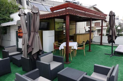 a patio with a table and chairs and umbrellas at Vila A&B in Bucharest