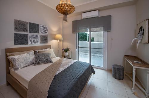 a bedroom with a bed and a window and a chandelier at Petite Fleur in Preveza