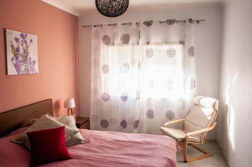 ラゴスにあるCasa Polaのベッドルーム1室(ベッド1台、椅子、窓付)