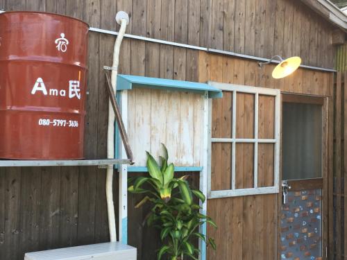 a building with a red barrel and a window at Guest house AmaMin in Amami