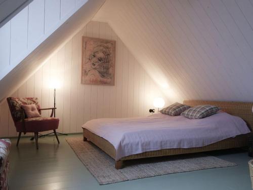 タンガーミュンデにあるSchrot-Kontorのベッドルーム1室(ベッド1台、屋根裏部屋の椅子付)