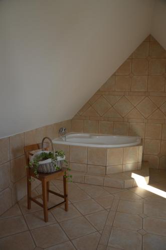 ein Bad im Dachgeschoss mit einer Badewanne und einem Tisch in der Unterkunft Nocleharna na stodole in Žďárky