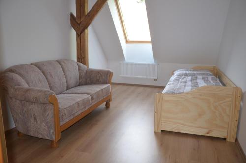 a living room with a couch and a bed at Nocleharna na stodole in Žďárky