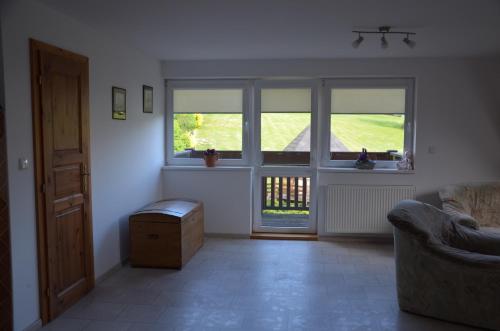 a living room with two windows and a couch at Nocleharna na stodole in Žďárky