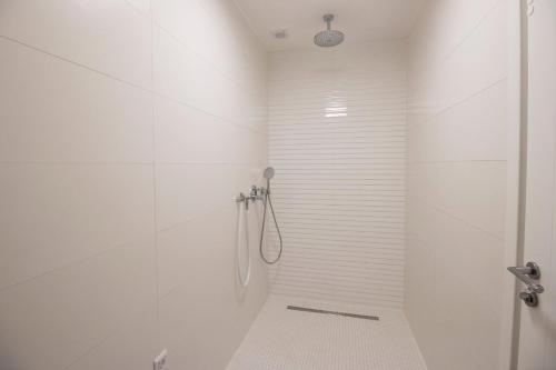 a bathroom with a shower with white tiles at Villa Median in Žman