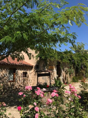 a stone house with pink flowers in front of it at la raymondiere in Vernoux-en-Gâtine