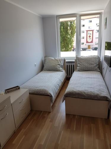グダニスクにあるApartament Przymorzeのベッドルーム1室(ベッド2台、窓付)