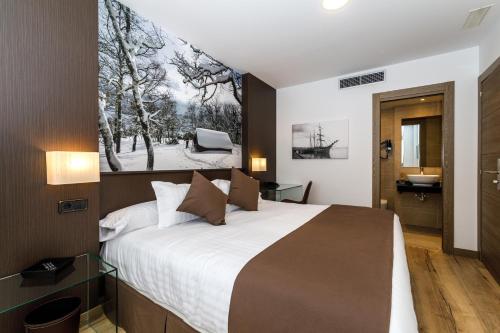 a bedroom with a large bed and a bathroom at Suite Home Pinares in Santander