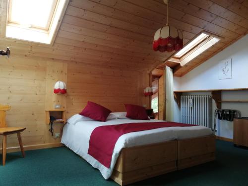 a bedroom with a large bed in a wooden room at Hotel il Cardo in San Vito di Cadore