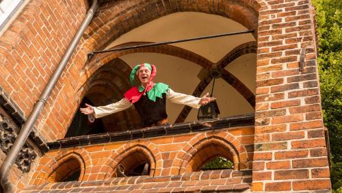 a statue of a clown standing on top of a brick building at Hotel Quellenhof in Mölln