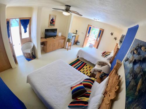 a bedroom with two beds and a television in it at Mar y Sueños in Sayulita
