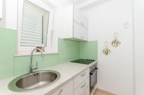a kitchen with a sink and a window at Beach & park Apartment in Kaštela