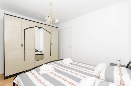 a bedroom with two beds and a large mirror at Beach & park Apartment in Kaštela