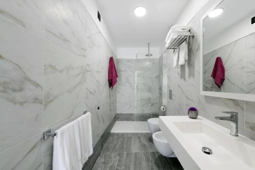 a white bathroom with a sink and a toilet at Best Western Hotel Principe di Lampedusa in Palermo
