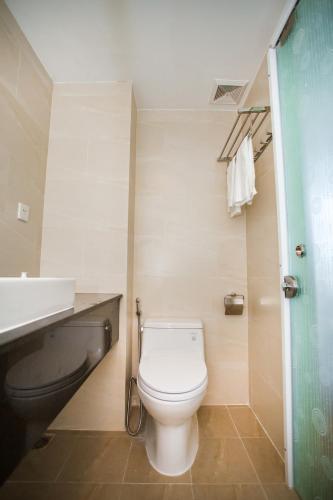 a bathroom with a white toilet and a sink at Moonlight Bay Hotel & Apartment in Nha Trang