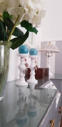 una mesa con un jarrón con flores blancas. en Casa Vittoria, en Milazzo