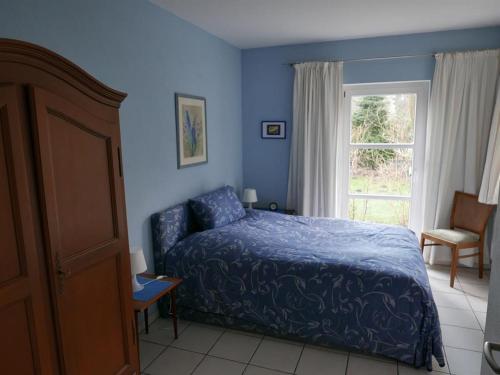 Dormitorio azul con cama y ventana en Ferienwohnung Prophet en Kiel