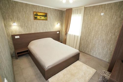 a small bedroom with a bed and a window at Райский Дворик in Pogreby