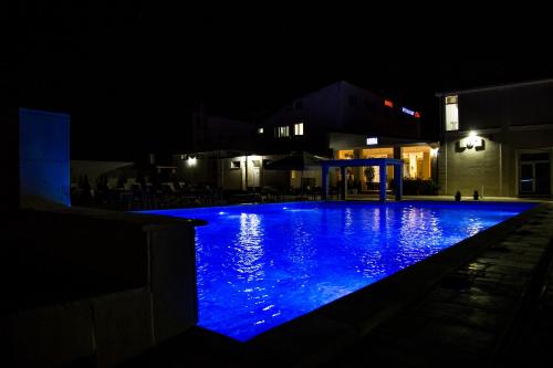 a swimming pool at night with blue lights at Hotel Restaurant Elite in Drobeta-Turnu Severin