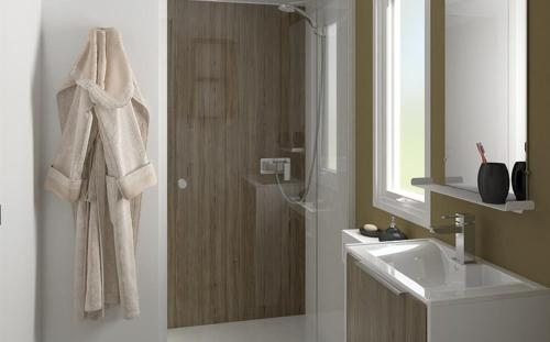 W łazience znajduje się prysznic, umywalka i lustro. w obiekcie Camping Le Village de la Mer w mieście Les Moutiers