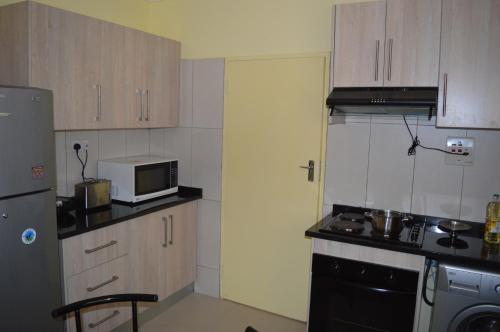 a small kitchen with a microwave and a stove at Kasuda House - Rent the entire house in Lusaka