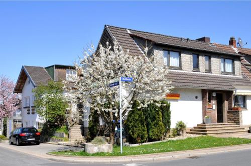 a tree in front of a house with a street sign at Pension Bella Vista in Bochum