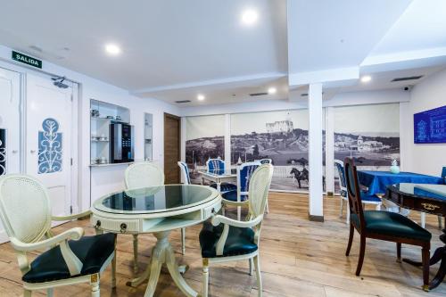 comedor con mesa de cristal y sillas en Suite Home Pinares, en Santander