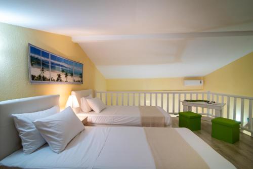 a hotel room with two beds and a table at Caretta Village in Toroni
