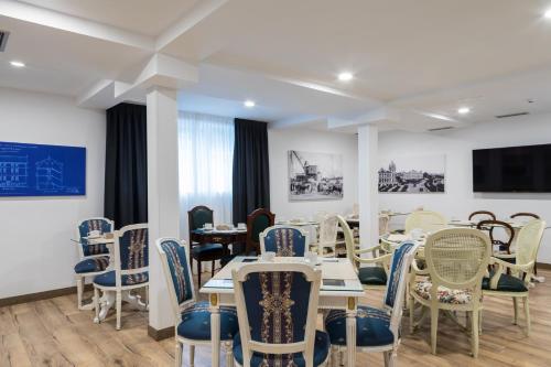 comedor con mesas y sillas y TV en Suite Home Pinares, en Santander