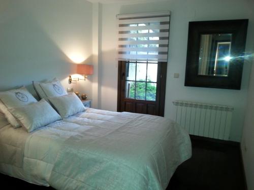 a bedroom with a large white bed with a window at Badaguas It's Cozy in Badaguás