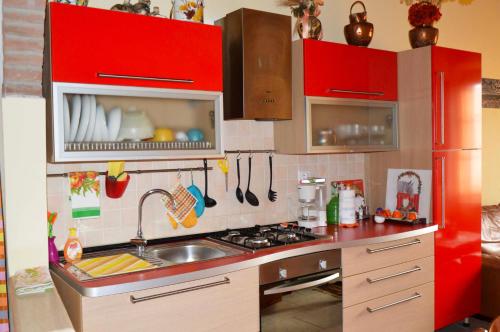 a kitchen with red cabinets and a sink at Sunflower in Palaia