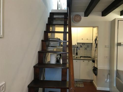 a wooden spiral staircase in a room with a kitchen at MANSARDA57 in Parma