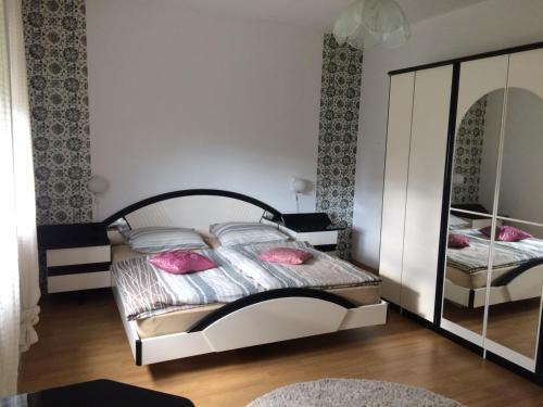 - une chambre avec 2 lits avec des oreillers roses et un miroir dans l'établissement Apartment Ana, à Rijeka