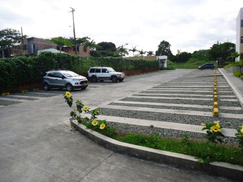 a parking lot with yellow flowers and cars parked at ApartaSol Reserva de la Colina in La Tebaida