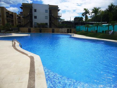 a large blue swimming pool next to a building at ApartaSol Reserva de la Colina in La Tebaida