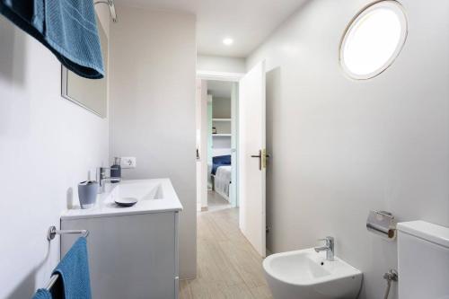 ein weißes Badezimmer mit Waschbecken und Spiegel in der Unterkunft Tagoro Park in Costa Del Silencio