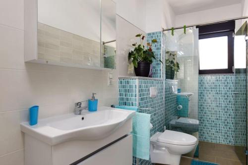 bagno con lavandino bianco e servizi igienici di APARTMENT RUZA - POOL a Donji Seget