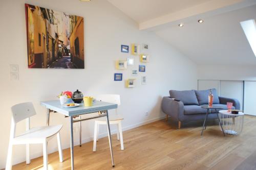 un salon avec une table et un canapé bleu dans l'établissement Ze Perfect Place - Superbe Studio Vieux Nice - calme et climatisé, à Nice