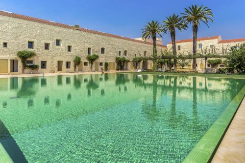 a large pool of water in front of a building at Convento das Bernardas Charming - Tavira in Tavira